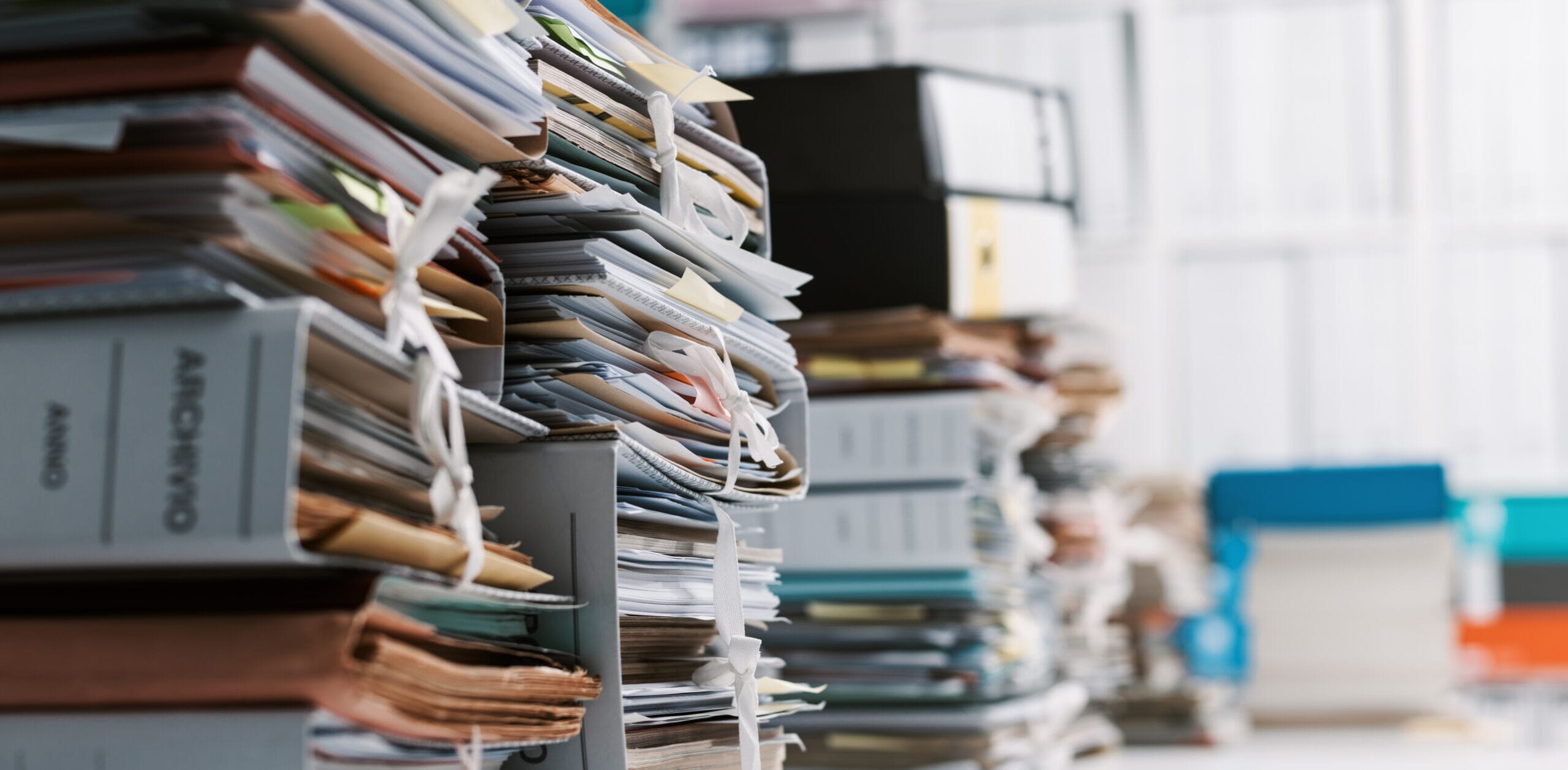 Piles-of-files-in-office_AdobeStock_191229458-scaled